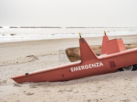 Rettungsruderboot am Strand. Der Text lautet: Notfall. Auf italienisch.