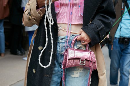 Photo for MILAN, ITALY - SEPTEMBER 21, 2022: Woman with pink, metallic Balenciaga bag and torn denim trousers before Calcaterra fashion show, Milan Fashion Week street style - Royalty Free Image