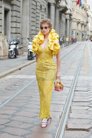Foto de MILÁN, ITALIA - 21 DE SEPTIEMBRE DE 2022: Mujer con vestido amarillo con cuello satinado antes del desfile de moda de Calcaterra, Milan Fashion Week street style - Imagen libre de derechos