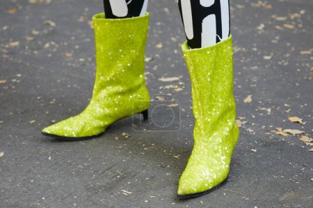 Téléchargez les photos : MILAN, ITALIE - 21 SEPTEMBRE 2022 : Femme avec des bottes à paillettes jaune-vert et un pantalon noir et blanc avant le défilé Fendi, Milan Fashion Week street style - en image libre de droit