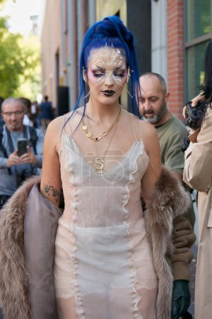 Photo for MILAN, ITALY - SEPTEMBER 21, 2022: Guest with white transparent dress blue hair and golden necklaces before Fendi fashion show, Milan Fashion Week street style - Royalty Free Image