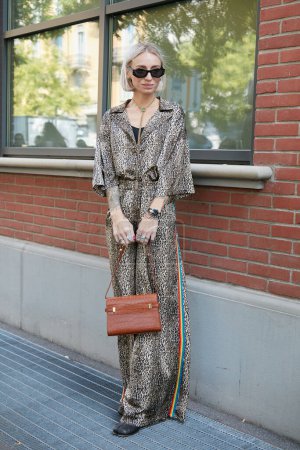 Téléchargez les photos : MILAN, ITALIE - 21 SEPTEMBRE 2022 : Femme avec une salopette en peau de léopard et un sac en simili-cuir marron avant le défilé de mode Fendi, Milan Fashion Week street style - en image libre de droit