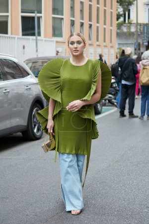 Téléchargez les photos : MILAN, ITALIE - 21 SEPTEMBRE 2022 : Femme avec robe verte avec épaules décoration et pantalon en denim avant le défilé de mode Alberta Ferretti, Milan Fashion Week street style - en image libre de droit