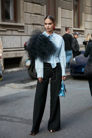 Téléchargez les photos : MILAN, ITALIE - 21 SEPTEMBRE 2022 : Femme avec pantalon noir, chemise bleue et décoration en tulle noir avant le défilé de mode Alberta Ferretti, Milan Fashion Week street style - en image libre de droit