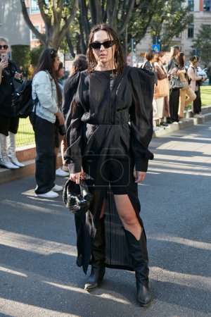 Téléchargez les photos : MILAN, ITALIE - 22 SEPTEMBRE 2022 : Femme avec robe noire et lunettes de soleil avant le défilé Emporio Armani, Milan Fashion Week street style - en image libre de droit