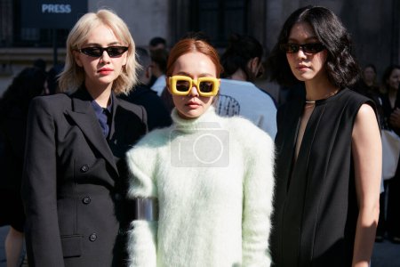 Foto de MILÁN, ITALIA - 23 DE SEPTIEMBRE DE 2022: Mujeres con chaqueta negra, vestido y cuello alto verde pálido antes del desfile de moda Sportmax, Milan Fashion Week street style - Imagen libre de derechos