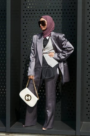 Téléchargez les photos : MILAN, ITALIE - 23 SEPTEMBRE 2022 : Aya Mohamed avec veste et pantalon en satin et sac Gucci en cuir blanc avant le défilé Gucci, Milan Fashion Week street style - en image libre de droit