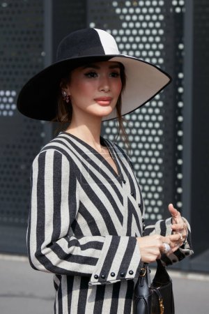 Foto de MILÁN, ITALIA - 23 DE SEPTIEMBRE DE 2022: Mujer con vestido de rayas grises y negras antes del desfile de moda Gucci, Milan Fashion Week street style - Imagen libre de derechos