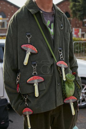 Photo for MILAN, ITALY - SEPTEMBER 23, 2022: Man with dark green velvet jacket and red mushrooms objects before Gucci fashion show, Milan Fashion Week street style - Royalty Free Image