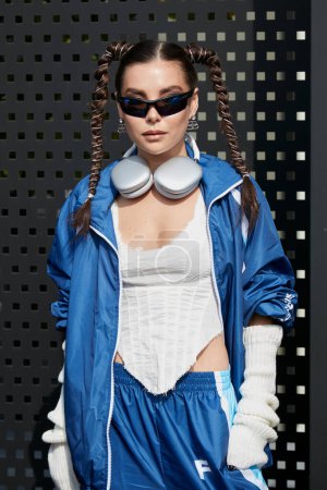 Photo for MILAN, ITALY - SEPTEMBER 23, 2022: Karina Nigay with blue sweatsuit, silver headphones and sunglasses before Gucci fashion show, Milan Fashion Week street style - Royalty Free Image