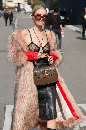 Foto de MILÁN, ITALIA - 23 DE SEPTIEMBRE DE 2022: Leonie Hanne con abrigo de piel rosa y bolso de piel de cocodrilo marrón y asa de bambú antes del desfile de moda Gucci, Milan Fashion Week street style - Imagen libre de derechos