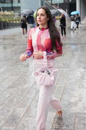 Foto de MILÁN, ITALIA - 24 DE SEPTIEMBRE DE 2022: Mujer con pantalones y bolso rosa pálido antes del desfile de moda MSGM, Milan Fashion Week street style - Imagen libre de derechos