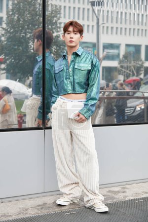 Foto de MILÁN, ITALIA - 24 DE SEPTIEMBRE DE 2022: Hombre con chaqueta metálica turquesa y pantalones beige antes del desfile de moda MSGM, Milan Fashion Week street style - Imagen libre de derechos