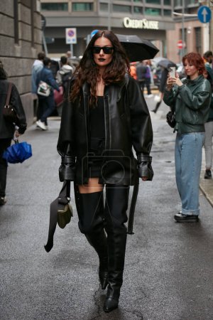 Téléchargez les photos : MILAN, ITALIE - 24 SEPTEMBRE 2022 : Femme avec veste en cuir noir et bottes hautes avant le défilé de mode Trussardi, Milan Fashion Week street style - en image libre de droit