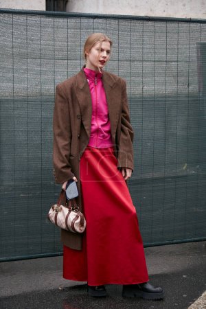 Foto de MILÁN, ITALIA - 24 DE SEPTIEMBRE DE 2022: Mujer con falda roja y abrigo marrón ante la Filosofía de Lorenzo Serafini desfile de moda, Milan Fashion Week street style - Imagen libre de derechos