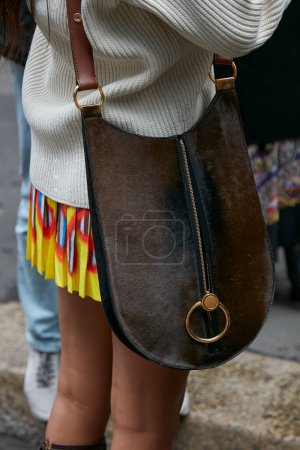 Foto de MILAN, ITALY - SEPTEMBER 25, 2022: Woman with brown leather and fur bag with golden ring before Luisa Spagnoli fashion show, Milan Fashion Week street style - Imagen libre de derechos