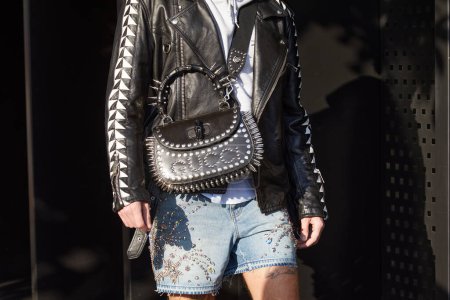 Foto de MILAN, ITALY - JANUARY 13, 2023: Man with black leather Gucci bag with studs before Gucci fashion show, Milan Fashion Week street style - Imagen libre de derechos