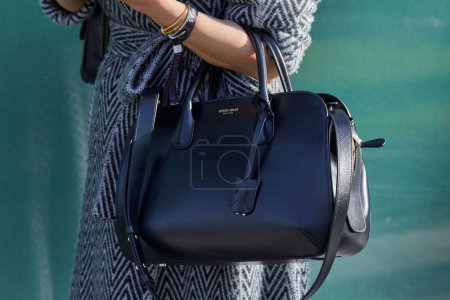 Téléchargez les photos : MILAN, ITALY - JANUARY 14, 2023: Woman with black leather Giorgio Armani bag before Emporio Armani fashion show, Milan Fashion Week street style - en image libre de droit