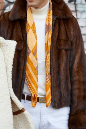 Téléchargez les photos : MILAN, ITALY - JANUARY 14, 2023: Man with brown fur jacket and yellow Fendi scarf and belt before Fendi fashion show, Milan Fashion Week street style - en image libre de droit