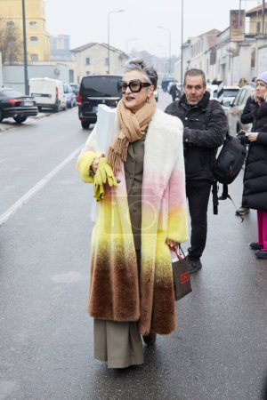 Foto de MILAN, ITALY - JANUARY 15, 2023: Woman with fur coat with soft gradient in white, pink, yellow and brown colors before Etro fashion show, Milan Fashion Week street style - Imagen libre de derechos