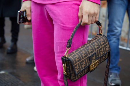 Photo for MILAN, ITALY - JANUARY 15, 2023: Man with pink trousers and brown Fendi bag with logo pattern before Etro fashion show, Milan Fashion Week street style - Royalty Free Image