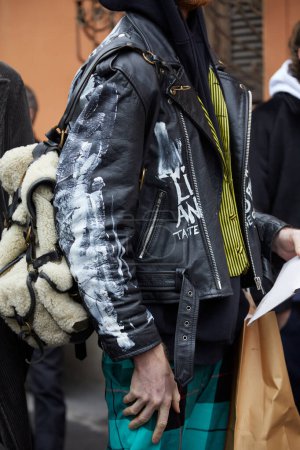 Téléchargez les photos : MILAN, ITALY - JANUARY 15, 2023: Man with black leather jacket with white designs before Etro fashion show, Milan Fashion Week street style - en image libre de droit