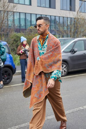 Téléchargez les photos : MILAN, ITALY - JANUARY 15, 2023: Man with beige cloak with floral design before Etro fashion show, Milan Fashion Week street style - en image libre de droit