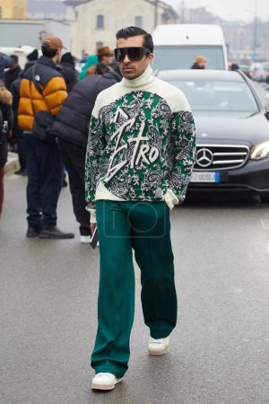 Foto de MILAN, ITALY - JANUARY 15, 2023: Man with green trousers and Etro turtleneck before Etro fashion show, Milan Fashion Week street style - Imagen libre de derechos