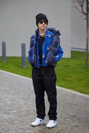 Téléchargez les photos : MILAN, ITALY - JANUARY 15, 2023: Man with blue padded jacket and black trousers before Etro fashion show, Milan Fashion Week street style - en image libre de droit