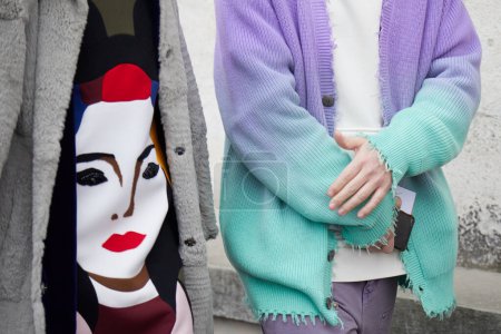 Téléchargez les photos : MILAN, ITALY - JANUARY 15, 2023: Woman and man with gray fur and purple and turquoise soft gradient sweater before Prada fashion show, Milan Fashion Week street style - en image libre de droit