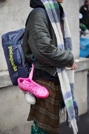 Foto de MILAN, ITALY - JANUARY 15, 2023: Man with pink and white Adidas sneakers and Patagonia bag before Prada fashion show, Milan Fashion Week street style - Imagen libre de derechos