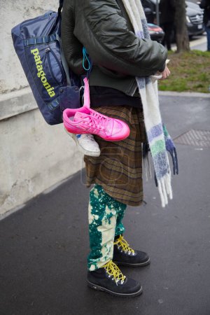 Foto de MILAN, ITALY - JANUARY 15, 2023: Man with pink and white Adidas sneakers and Patagonia bag before Prada fashion show, Milan Fashion Week street style - Imagen libre de derechos