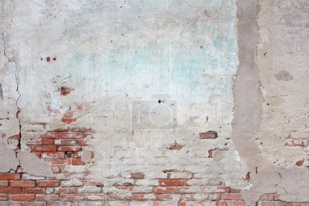 Stary mur ceglany i zniszczony szary tynk z pęknięciami tekstury tła