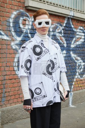 Téléchargez les photos : MILAN, ITALIE - 22 FÉVRIER 2023 : Homme avec des lunettes de soleil en fourrure blanche et chemise avec design de cassette avant le défilé de mode Fendi, Milan Fashion Week street style - en image libre de droit
