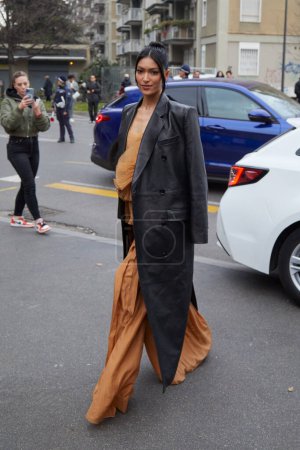 Téléchargez les photos : MILAN, ITALIE - 22 FÉVRIER 2023 : Pritika Swarup avec un long trench en cuir noir et une robe marron avant le défilé de mode Alberta Ferretti, Milan Fashion Week street style - en image libre de droit