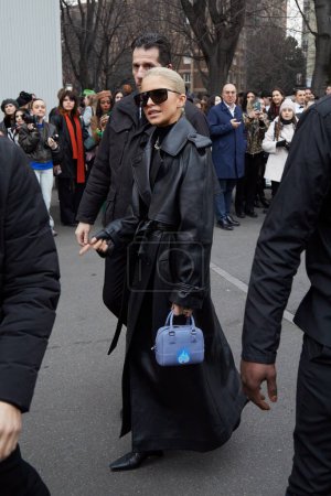 Foto de MILÁN, ITALIA - 22 DE FEBRERO DE 2023: Caro Daur con gabardina de cuero negro antes del desfile de moda Alberta Ferretti, Milan Fashion Week street style - Imagen libre de derechos