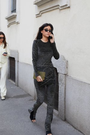 Téléchargez les photos : MILAN, ITALIE - 23 FÉVRIER 2023 : Femme avec robe et pantalon noir et blanc avec motif en cuir de crocodile avant le défilé de mode Genny, Milan Fashion Week street style - en image libre de droit