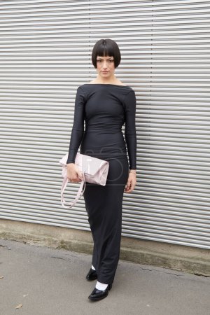 Foto de MILÁN, ITALIA - 23 DE FEBRERO DE 2023: Mujer con vestido negro y bolso de cuero rosa Prada antes del desfile de moda Prada, Milan Fashion Week street style - Imagen libre de derechos