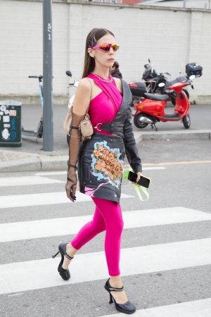 Photo for MILAN, ITALY - FEBRUARY 23, 2023: Woman with pink jumpsuit and black leather skirt with graffiti design before Prada fashion show, Milan Fashion Week street style - Royalty Free Image
