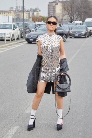 Téléchargez les photos : MILAN, ITALIE - 23 FÉVRIER 2023 : Femme avec robe argentée et sac Jacquemus noir avant le défilé Prada, Milan Fashion Week street style - en image libre de droit
