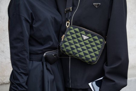 Photo for MILAN, ITALY - FEBRUARY 23, 2023: Woman and man with black dress and green and black Prada bag before Prada fashion show, Milan Fashion Week street style - Royalty Free Image