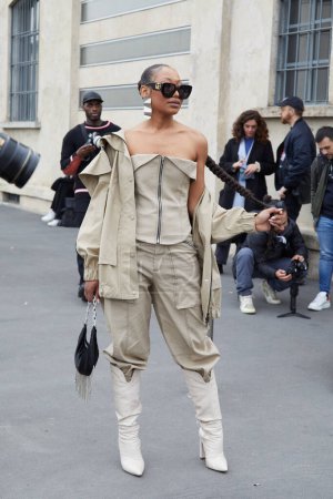 Téléchargez les photos : MILAN, ITALIE - 23 FÉVRIER 2023 : Femme avec veste et pantalon beige et lunettes de soleil noires avant le défilé Prada, Milan Fashion Week street style - en image libre de droit