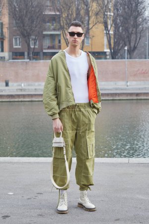 Téléchargez les photos : MILAN, ITALIE - 24 FÉVRIER 2023 : Homme avec veste vert olive et pantalon cargo avant le défilé Sportmax, Milan Fashion Week street style - en image libre de droit