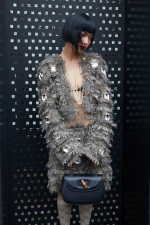 Foto de MILÁN, ITALIA - 24 DE FEBRERO DE 2023: Mujer con chaqueta gris y falda con pedrería grande y bolso Gucci antes del desfile de moda Gucci, Milan Fashion Week street style - Imagen libre de derechos