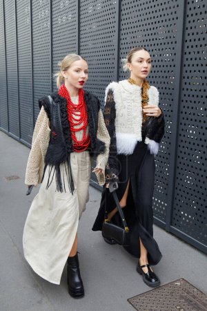 Téléchargez les photos : MILAN, ITALIE - 24 FÉVRIER 2023 : Femmes avec robe beige et col rouge et robe noire avant le défilé Gucci, Milan Fashion Week street style - en image libre de droit
