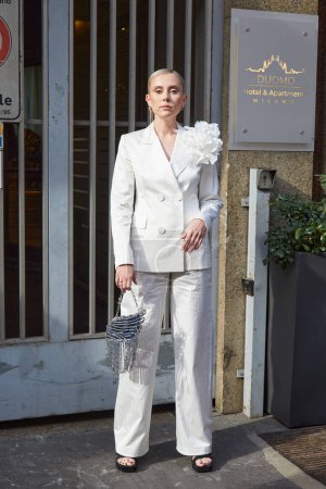 Téléchargez les photos : MILAN, ITALIE - 25 FÉVRIER 2023 : Femme avec veste blanche et pantalon à fleur blanche avant le défilé Ermanno Scervino, Milan Fashion Week street style - en image libre de droit