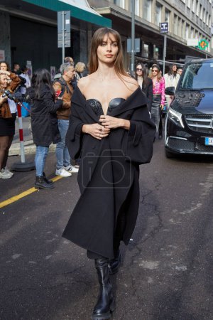 Téléchargez les photos : MILAN, ITALIE - 25 FÉVRIER 2023 : Mara Lafontan avec robe et manteau en cuir noir avant le défilé Ermanno Scervino, Milan Fashion Week street style - en image libre de droit