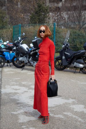Téléchargez les photos : MILAN, ITALIE - 25 FÉVRIER 2023 : Femme avec col roulé rouge et jupe avec sac en cuir noir avant le défilé Ferragamo, Milan Fashion Week street style - en image libre de droit