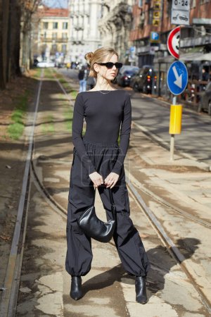 Téléchargez les photos : MILAN, ITALIE - 25 FÉVRIER 2023 : Femme avec chemise et pantalon noirs avant le défilé Dolce and Gabbana, Milan Fashion Week street style - en image libre de droit