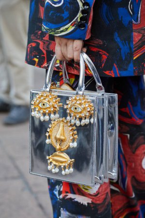 Photo for MILAN, ITALY - FEBRUARY 25, 2023: Woman with silver bag with golden face details before Missoni fashion show, Milan Fashion Week street style - Royalty Free Image